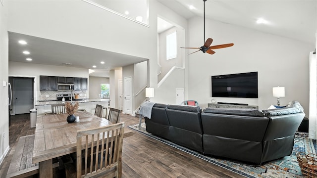 201 Garcitas Creek Ln, Hutto, TX 78634 - living room featuring dark wood finished floors, high vaulted ceiling, ceiling fan, recessed lighting, and stairs