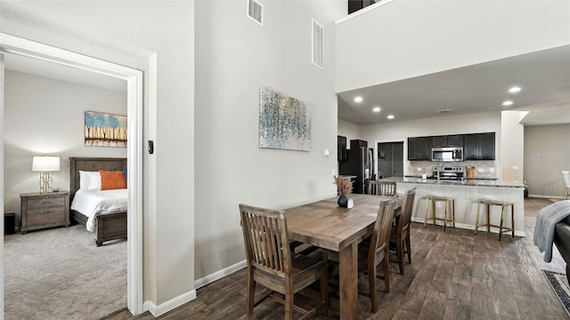 201 Garcitas Creek Ln, Hutto, TX 78634 - dining room featuring dark wood-style flooring, recessed lighting, and a high ceiling