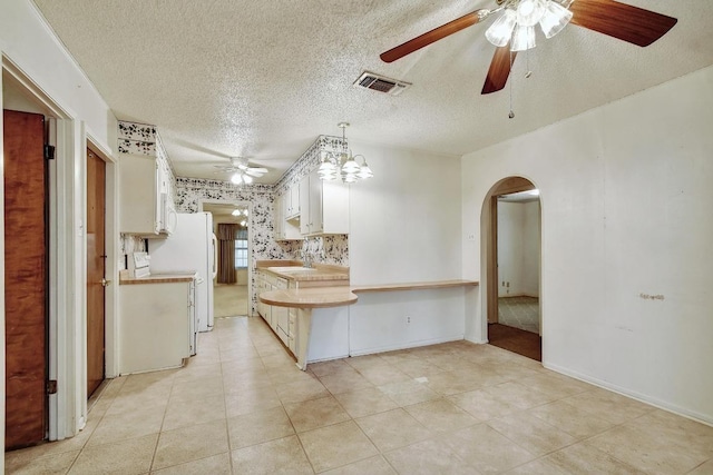 7546 Leafy Hollow Ct, Live Oak, TX 78233 - kitchen with a ceiling fan, arched walkways, light countertops, a textured ceiling, and white cabinets