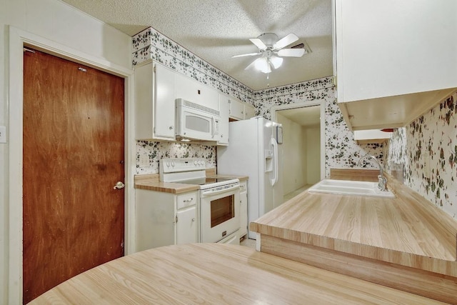 7546 Leafy Hollow Ct, Live Oak, TX 78233 - kitchen with white appliances, wallpapered walls, a ceiling fan, a textured ceiling, and white cabinetry
