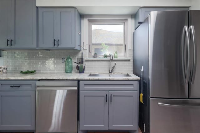 1912 Gaylord Dr, Austin, TX 78728 - kitchen featuring stainless steel appliances, backsplash, gray cabinets, and light stone countertops