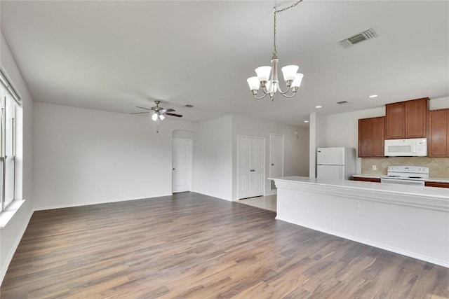 933 Oatmeal Dr, Pflugerville, TX 78660 - kitchen featuring white appliances, a chandelier, wood finished floors, backsplash, and ceiling fan