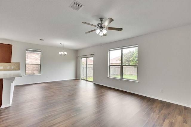 933 Oatmeal Dr, Pflugerville, TX 78660 - unfurnished living room featuring a chandelier, ceiling fan, and dark wood-style floors