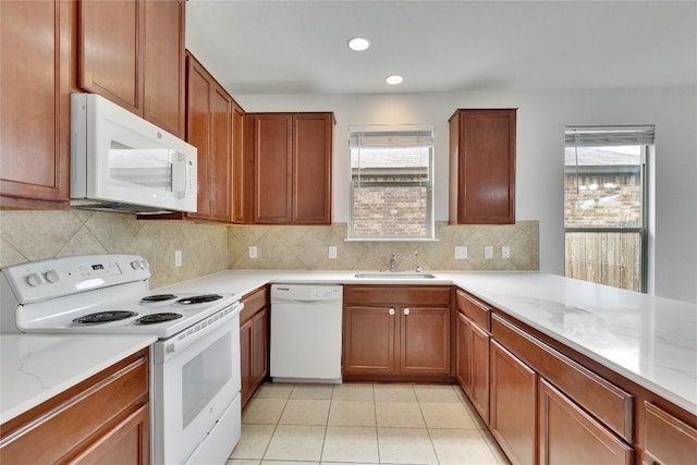 933 Oatmeal Dr, Pflugerville, TX 78660 - kitchen featuring white appliances, healthy amount of natural light, backsplash, light stone counters, and recessed lighting