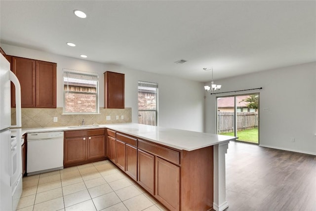 933 Oatmeal Dr, Pflugerville, TX 78660 - kitchen with white dishwasher, healthy amount of natural light, a peninsula, light countertops, and recessed lighting