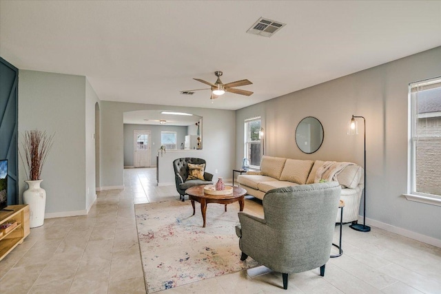 215 Peaceful Haven Way, Hutto, TX 78634 - living room with arched walkways, ceiling fan, and light tile patterned floors