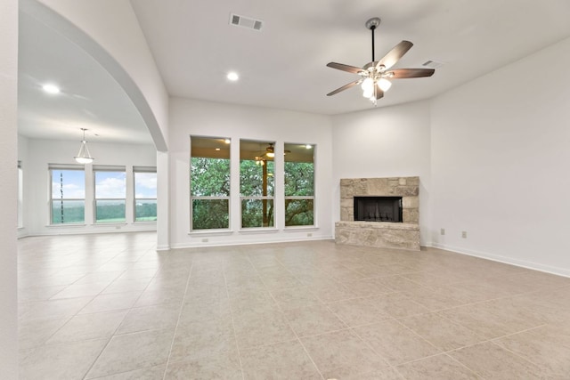 851 Stone Mountain Dr, Marble Falls, TX 78654 - unfurnished living room with ceiling fan, light tile patterned flooring, a fireplace, recessed lighting, and arched walkways
