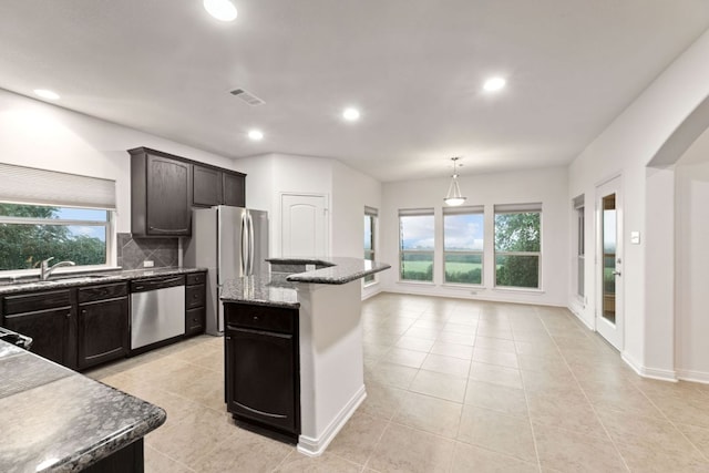 851 Stone Mountain Dr, Marble Falls, TX 78654 - kitchen featuring appliances with stainless steel finishes, plenty of natural light, tasteful backsplash, light tile patterned floors, and recessed lighting