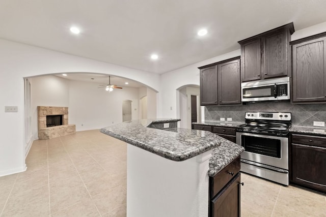 851 Stone Mountain Dr, Marble Falls, TX 78654 - kitchen featuring stainless steel appliances, arched walkways, ceiling fan, a center island, and recessed lighting