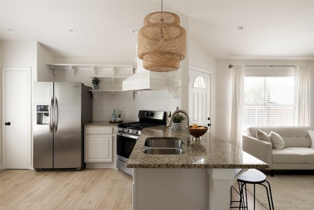 701 Mankato Dr, Austin, TX 78748 - kitchen featuring appliances with stainless steel finishes, open shelves, decorative backsplash, light wood-style flooring, and stone countertops