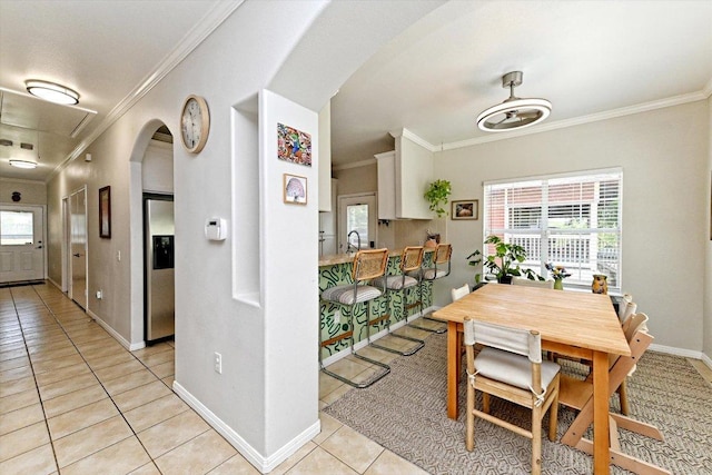7312 Meador Ave, Austin, TX 78752 - dining room with arched walkways, crown molding, and light tile patterned flooring