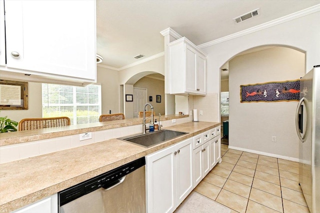 7312 Meador Ave, Austin, TX 78752 - kitchen featuring stainless steel appliances, crown molding, arched walkways, white cabinets, and light countertops