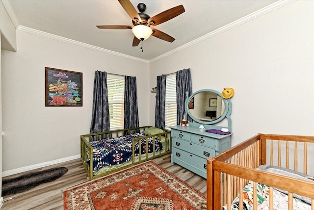 7312 Meador Ave, Austin, TX 78752 - bedroom featuring wood finished floors, crown molding, a crib, and a ceiling fan
