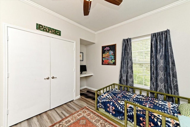 7312 Meador Ave, Austin, TX 78752 - bedroom featuring wood finished floors, crown molding, a closet, and ceiling fan