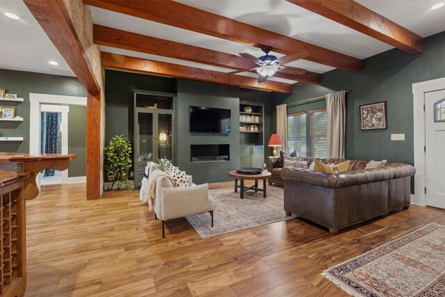 79 Saddle Rock Rdg, Wimberley, TX 78676 - living area with wood finished floors, beamed ceiling, a ceiling fan, recessed lighting, and a fireplace