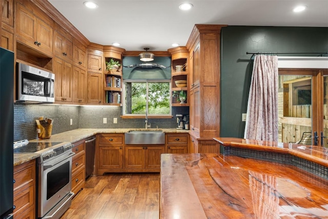 79 Saddle Rock Rdg, Wimberley, TX 78676 - kitchen with stainless steel appliances, open shelves, brown cabinets, light wood-style flooring, and wood counters