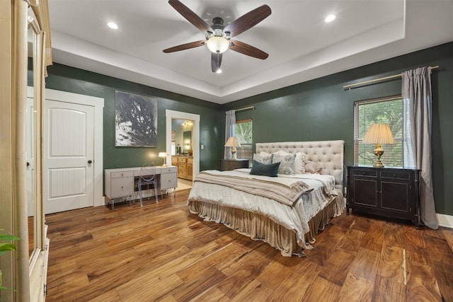 79 Saddle Rock Rdg, Wimberley, TX 78676 - bedroom with a tray ceiling, wood finished floors, recessed lighting, ensuite bathroom, and a ceiling fan
