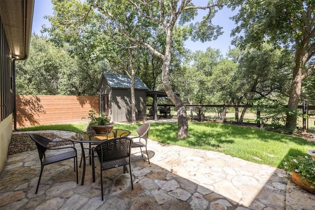 79 Saddle Rock Rdg, Wimberley, TX 78676 - fenced backyard with a patio, a storage unit, and view of wooded area