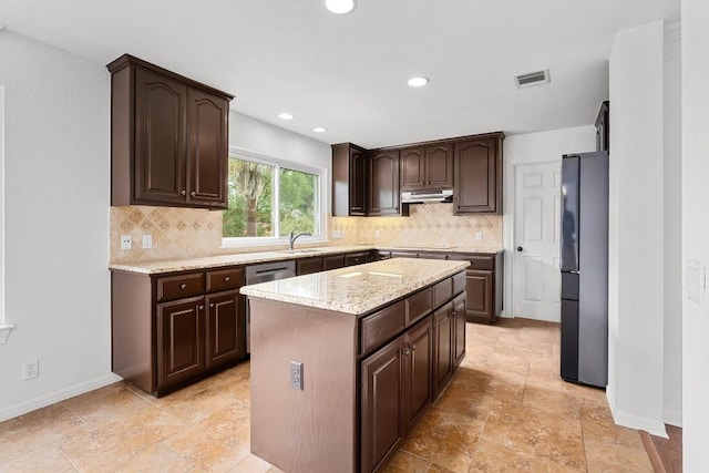 10504 Grand Oak Cir, Austin, TX 78750 - kitchen featuring freestanding refrigerator, under cabinet range hood, dark brown cabinetry, decorative backsplash, and a center island