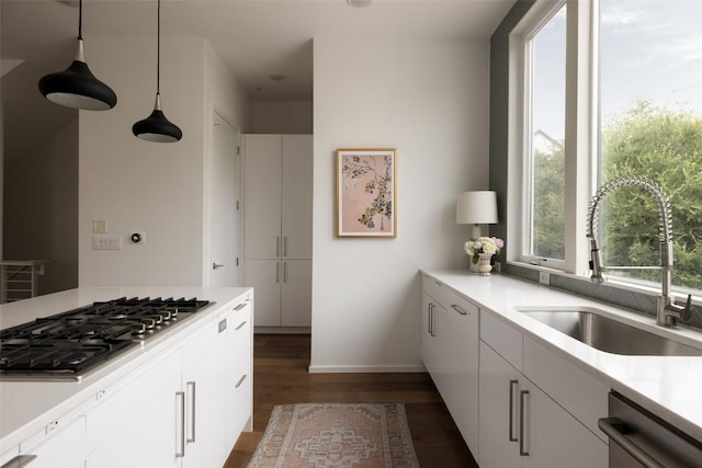 3100 Menchaca Rd Unit 10, Austin, TX 78704 - kitchen with stainless steel appliances, dark wood-style floors, light countertops, white cabinets, and hanging light fixtures