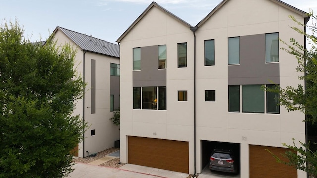 3100 Menchaca Rd Unit 10, Austin, TX 78704 - view of front of house featuring an attached garage, stucco siding, and concrete driveway