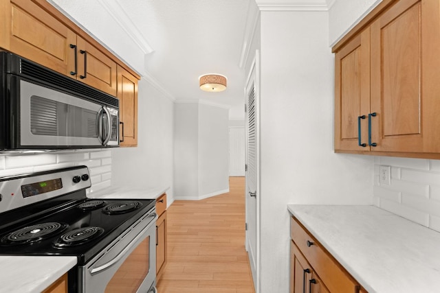 900 S Lamar Blvd Unit 304, Austin, TX 78704 - kitchen with electric range, crown molding, light wood-type flooring, light countertops, and backsplash