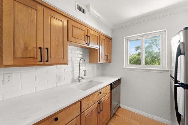 900 S Lamar Blvd Unit 304, Austin, TX 78704 - kitchen featuring stainless steel appliances, backsplash, crown molding, brown cabinets, and light wood-style flooring