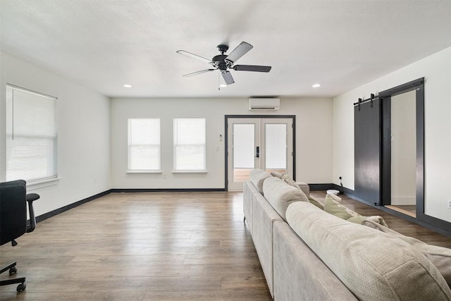 13516 Caldwell Dr, Austin, TX 78750 - living area with healthy amount of natural light, a ceiling fan, an AC wall unit, wood finished floors, and recessed lighting
