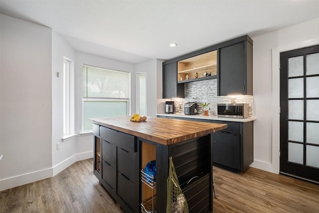 13516 Caldwell Dr, Austin, TX 78750 - kitchen with stainless steel microwave, wood counters, open shelves, decorative backsplash, and wood finished floors