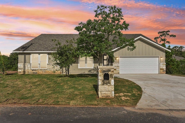 130 Mokalau Dr, Bastrop, TX 78602 - view of front of property featuring stone siding, driveway, a garage, and a front lawn
