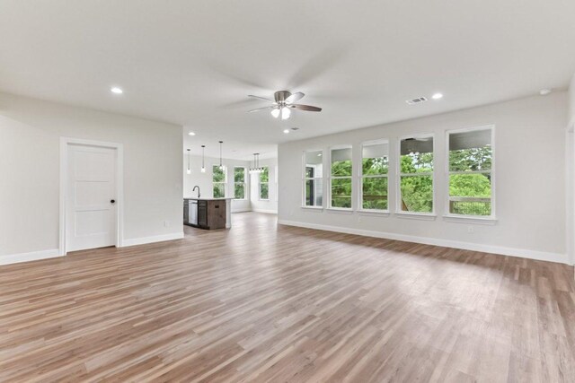 130 Mokalau Dr, Bastrop, TX 78602 - unfurnished living room with a ceiling fan, light wood-style floors, and recessed lighting