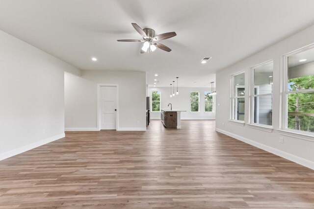 130 Mokalau Dr, Bastrop, TX 78602 - unfurnished living room featuring ceiling fan, light wood-style flooring, and recessed lighting