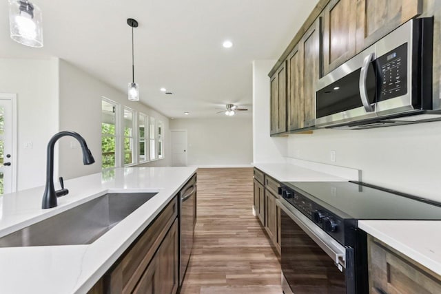 130 Mokalau Dr, Bastrop, TX 78602 - kitchen with stainless steel appliances, light wood-style flooring, decorative light fixtures, recessed lighting, and light countertops