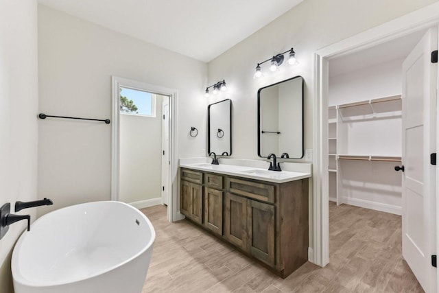 130 Mokalau Dr, Bastrop, TX 78602 - bathroom featuring a freestanding bath, double vanity, and a walk in closet
