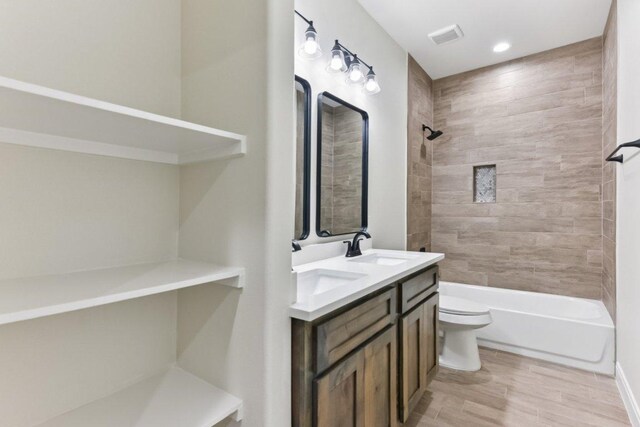 130 Mokalau Dr, Bastrop, TX 78602 - bathroom with double vanity, wood finished floors, washtub / shower combination, and recessed lighting