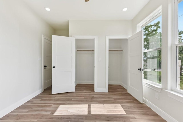 130 Mokalau Dr, Bastrop, TX 78602 - unfurnished bedroom featuring two closets, light wood-style flooring, and recessed lighting