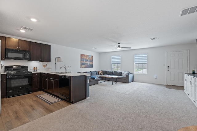 17704 Oso Cv, Elgin, TX 78621 - kitchen featuring black appliances, ceiling fan, a peninsula, dark brown cabinetry, and open floor plan