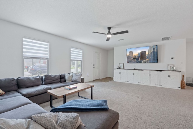 17704 Oso Cv, Elgin, TX 78621 - living room featuring a ceiling fan, light carpet, and a textured ceiling