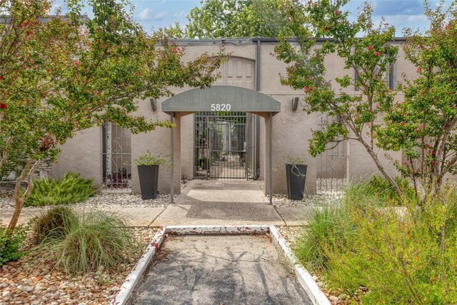 5820 Berkman Dr Unit 205, Austin, TX 78723 - entrance to property with a gate, stucco siding, and uncovered parking