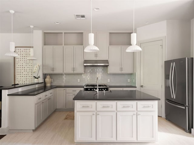 5408 Prock Ln Unit A, Austin, TX 78721 - kitchen featuring stainless steel fridge, exhaust hood, dark countertops, an island with sink, and decorative backsplash
