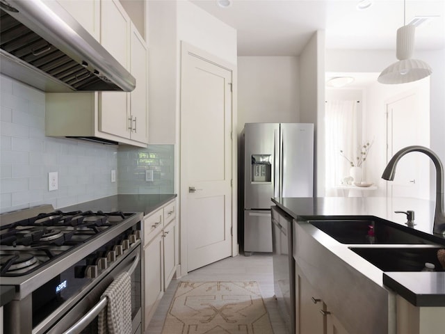 5408 Prock Ln Unit A, Austin, TX 78721 - kitchen featuring exhaust hood, appliances with stainless steel finishes, tasteful backsplash, light marble finish floors, and white cabinets