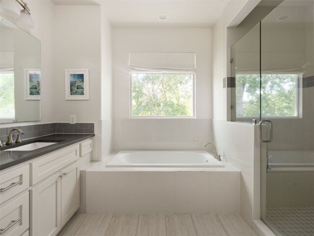 5408 Prock Ln Unit A, Austin, TX 78721 - full bath featuring vanity, a bath, a shower stall, and wood finished floors