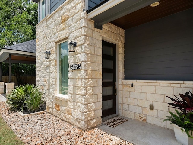 5408 Prock Ln Unit A, Austin, TX 78721 - view of exterior entry featuring stone siding and a shingled roof