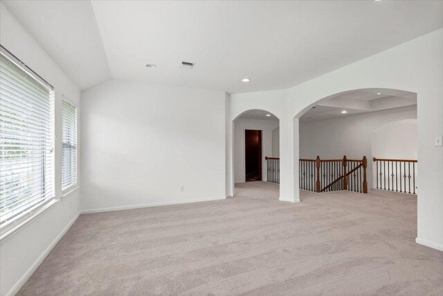211 Longmont Ln, Austin, TX 78737 - spare room featuring light colored carpet, recessed lighting, lofted ceiling, and arched walkways