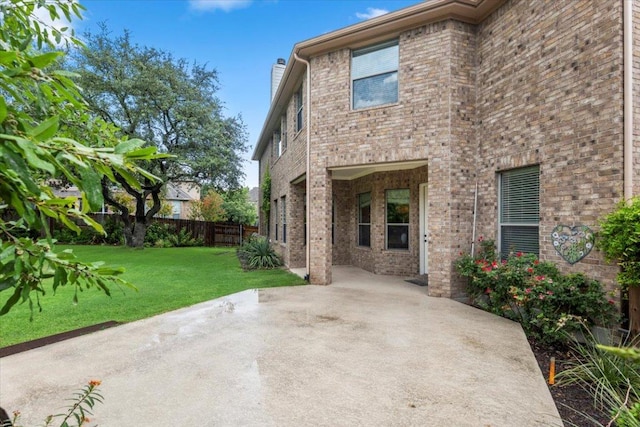 211 Longmont Ln, Austin, TX 78737 - rear view of house with a patio area, a chimney, and brick siding