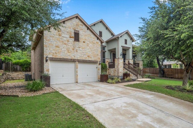 211 Longmont Ln, Austin, TX 78737 - view of front of home featuring stone siding, a garage, driveway, and stucco siding