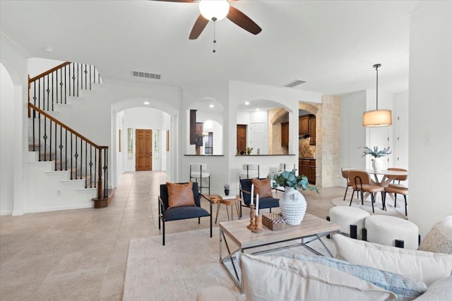 211 Longmont Ln, Austin, TX 78737 - living area featuring arched walkways, a ceiling fan, stairway, crown molding, and light tile patterned floors