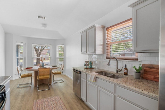 9273 Vigen Cir, Austin, TX 78748 - kitchen featuring stainless steel dishwasher, tasteful backsplash, light wood-style flooring, and healthy amount of natural light
