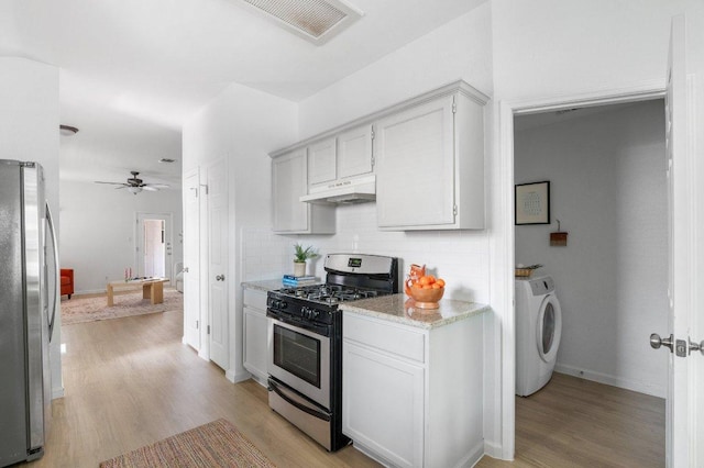 9273 Vigen Cir, Austin, TX 78748 - kitchen with stainless steel appliances, under cabinet range hood, decorative backsplash, independent washer and dryer, and light wood finished floors