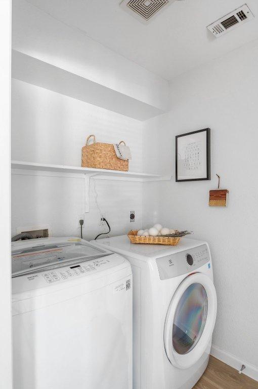 9273 Vigen Cir, Austin, TX 78748 - laundry area with washing machine and clothes dryer and light wood finished floors